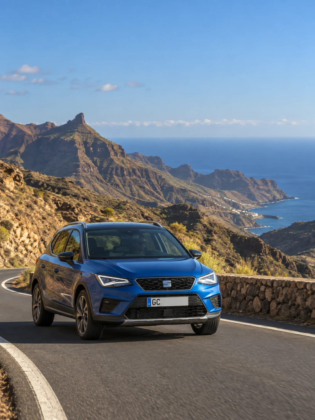 A blue crossover on a mountain road